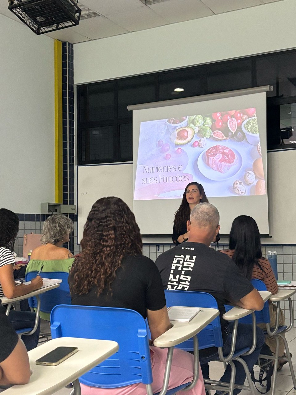 Flávia Maitri ministrando aula sobre nutrição — tema Corpo e Saúde